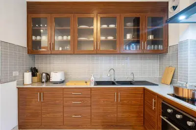 a kitchen with wooden cabinets and a sink at Golden Sands Villa only 15 minutes walk to beach in Surin Beach