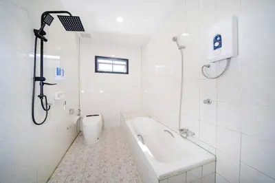 a white bathroom with a tub and a shower at Golden Sands Villa only 15 minutes walk to beach in Surin Beach