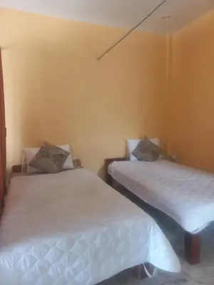 two beds in a room with white sheets at Salika Hostel Patong Phuket in Patong Beach