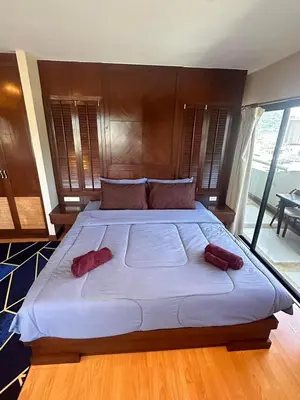a large bed with two red pillows on it at Patong Tower Apartment - AMP in Patong Beach