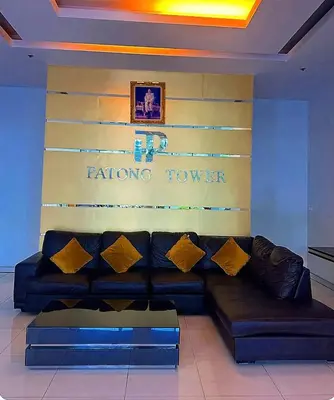 a living room with a leather couch in front of a wall at Patong Tower Apartment - AMP in Patong Beach