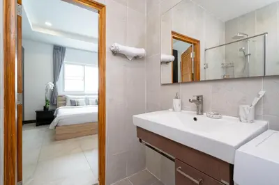 a bathroom with a sink and a mirror and a bed at Apartment 1 Bedroom in Naiharn t in Ban Saiyuan (1)