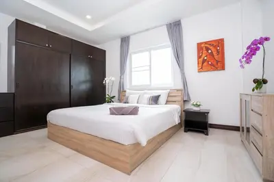 a bedroom with a large bed with a wooden cabinet at Apartment 1 Bedroom in Naiharn t in Ban Saiyuan (1)