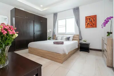 a bedroom with a bed and a vase of flowers at Apartment 1 Bedroom in Naiharn t in Ban Saiyuan (1)