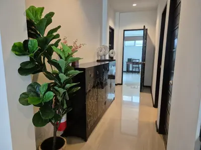 a hallway with a black cabinet and a potted plant at Oxygen Condominium Bangtao in Ban Thalat Choeng Thale