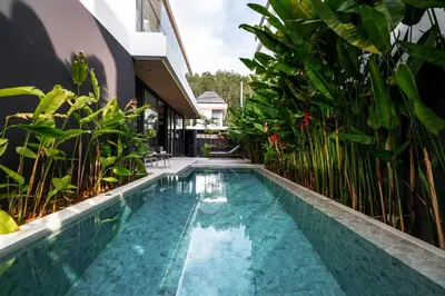 a swimming pool in the middle of a house with plants at Grand Villa Aileen in Nai Yang Beach