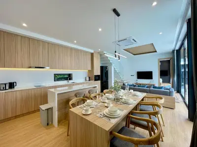 a dining room and kitchen with a table and chairs at Grand Villa Aileen in Nai Yang Beach