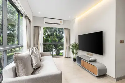 a living room with a couch and a flat screen tv at Laguna Lakeside BangTao by My Home Phuket in Bang Tao Beach