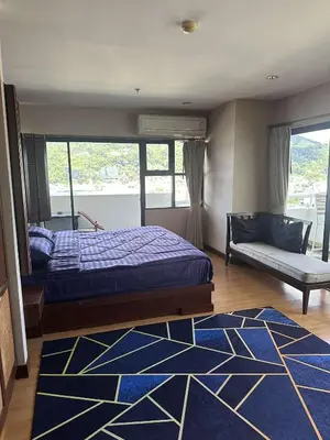 a bedroom with a bed and a couch and a window at Apartment in Patong Tower in Patong Beach