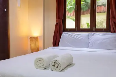 a bed with two towels on it with a window at V235 Huge Pool 4 Mins Kamala Beach 12 Mins Patong in Kamala Beach