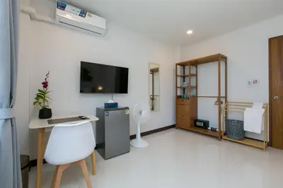 a white room with a desk and a tv in it at Wow Academy & Stay Soi Tai-Aed 2A in Ban Suan
