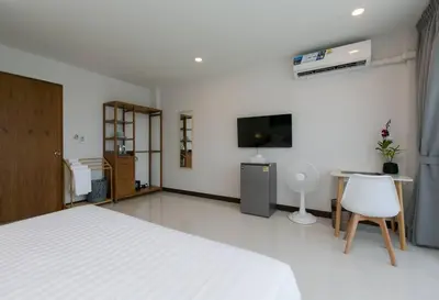 a bedroom with a bed and a desk and a tv at Wow Academy & Stay Soi Tai-Aed 3A in Ban Suan
