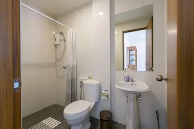 a white bathroom with a toilet and a sink at Wow Academy & Stay Soi Tai-Aed 3A in Ban Suan
