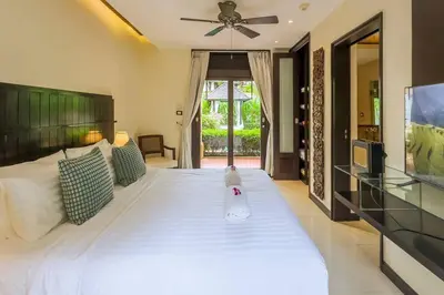 a bedroom with a large white bed with a ceiling fan at Charming Chom Tawan Villa 3 bdr in Layan Beach