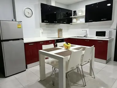 a kitchen with a white table and a white refrigerator at Private apartment at Phuket Villa Condo in Patong Beach