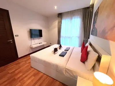 a bedroom with a bed with two cats sitting on it at EMERALD TERRACE CONDO 52-FAMILY 1 Bedroom POOL VIEW in Patong Beach