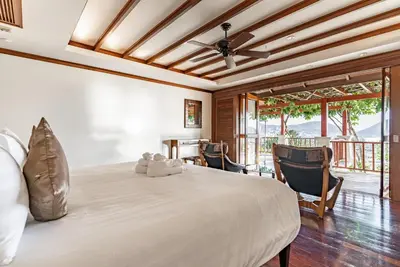 a bedroom with a large white bed and chairs at Villa Suriya B2 in Patong Beach