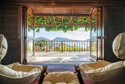 a living room with two chairs and a large window at Villa Suriya B2 in Patong Beach