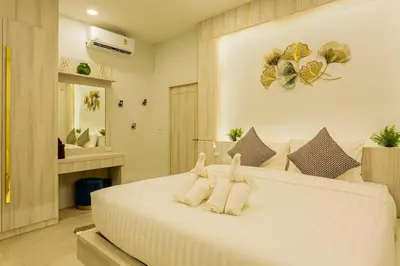 a bedroom with a large white bed with two towels at Pool Villa No 10 by Duangtham in Ban Khlong Haeng