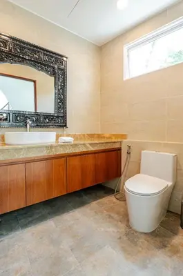a bathroom with a toilet and a sink and a mirror at Kyerra 88-16 An exquisite mansion with eclectic interiors in Phuket Town
