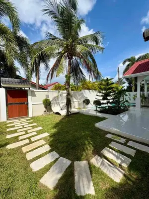a palm tree in the yard of a house at Villa Happy home in Rawai Beach