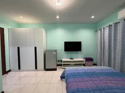 a bedroom with a bed and a flat screen tv at Best Rent a Room in Nai Yang Beach