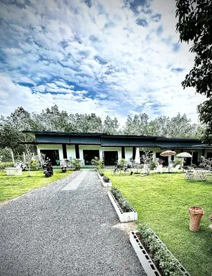 a building with a road in front of a field at Da Airport Hotel in Nai Yang Beach