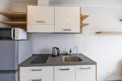 a white kitchen with a sink and a refrigerator at Modern Condo near the Beach - NV531 in Phuket Town