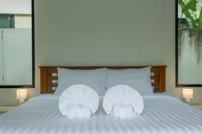 two white pillows sitting on a bed with two lamps at 2 Beds large pool night market Soi Namjai v122 in Rawai Beach