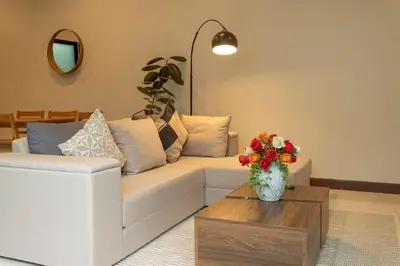 a living room with a white couch and a vase of flowers at 2 Beds large pool night market Soi Namjai v122 in Rawai Beach