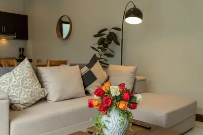 a living room with a couch with a vase of flowers at 2 Beds large pool night market Soi Namjai v122 in Rawai Beach