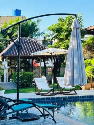two lounge chairs and an umbrella next to a pool at Studio Room with private kitchen and Bathroom in Ban Phlu Yai