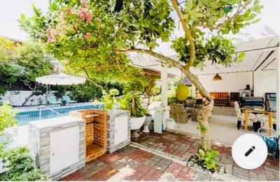 a house with a tree and a swimming pool at Studio Room with private kitchen and Bathroom in Ban Phlu Yai
