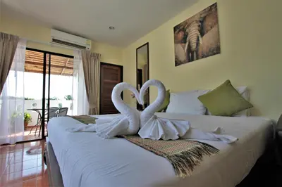 two swans are carved into a bed in a bedroom at Karon Pool Hotel in Karon Beach