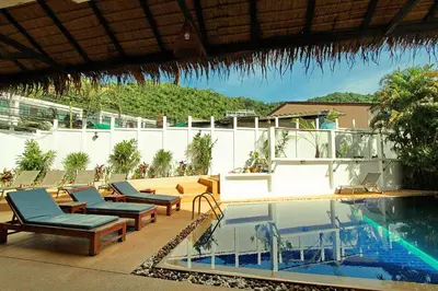 a pool with chaise lounge chairs and a swimming pool at Karon Pool Hotel in Karon Beach