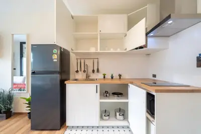 a kitchen with white cabinets and a refrigerator at The Halo 1 Naiyang Beach in Nai Yang Beach