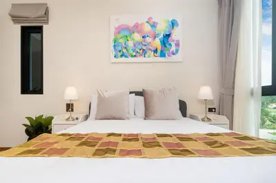 a bedroom with a bed with a colorful quilt on it at The Halo 1 Naiyang Beach in Nai Yang Beach