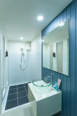 a bathroom with a sink and a mirror at The Light House at Town Phuket in Phuket Town