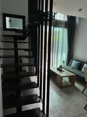a black spiral staircase in a living room with a couch at Utopia Naiharn Beach B16 in Rawai Beach
