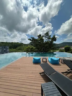 a swimming pool with blue pillows on a wooden deck at Utopia Naiharn Beach B17 in Rawai Beach