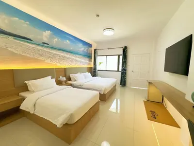 a hotel room with two beds and a flat screen tv at The coconut nanai resort in Patong Beach