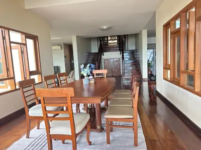 a dining room with a wooden table and chairs at Villa Moon Talay View in Patong Beach