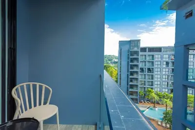a balcony with a chair and a view of a building at C141 Fully Loaded Best Facilities Nicest Apartment in Kamala Beach