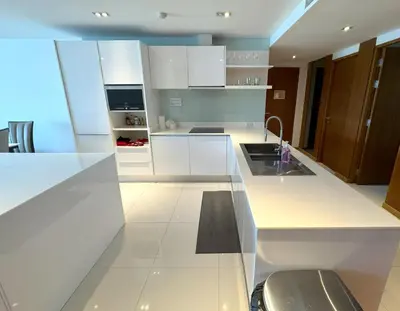 a white kitchen with white cabinets and a sink at Sea view apartment at Privilege by Lofty in Patong Beach