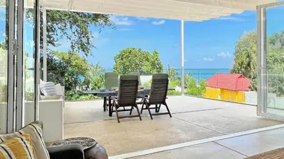 a dining room with a view of the ocean at At the Beach Spacious 2-level Design Home for 2-5 and 1 infant, Ao Yon Beach Phuket in Ban Ao Makham