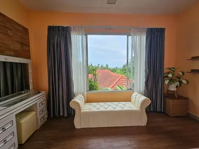 a living room with a couch and a large window at Andaman homestay villa at rawai in Ban Saiyuan (1)
