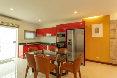a kitchen with red cabinets and a table and chairs at 12 minutes Patong Security Gym Sauna AP12 #V28 in Kamala Beach