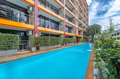 a swimming pool in front of a building at Уютные апартаменты NBC Nai Harn in Rawai Beach