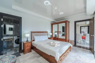 a bedroom with a large bed and a bathroom at Уютные апартаменты NBC Nai Harn in Rawai Beach
