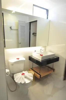 a bathroom with a toilet and a sink and a mirror at Forty Winks Phuket Hotel in Patong Beach